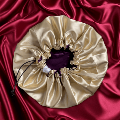 Beige drawstring bag on a red satin background