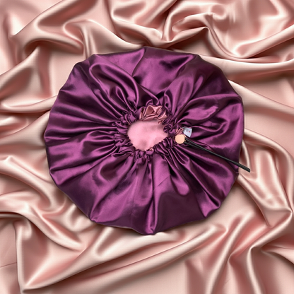 Purple satin hair bonnet on pink satin fabric