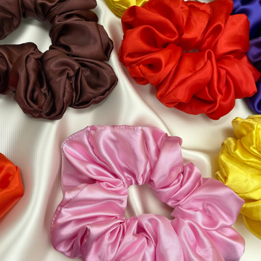 Collection of colorful satin scrunchies on a white background