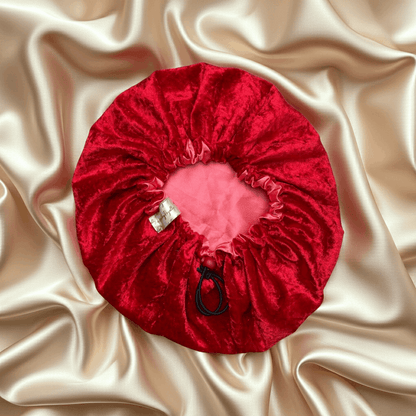 Red velvet drawstring bag with a pink interior on beige satin fabric