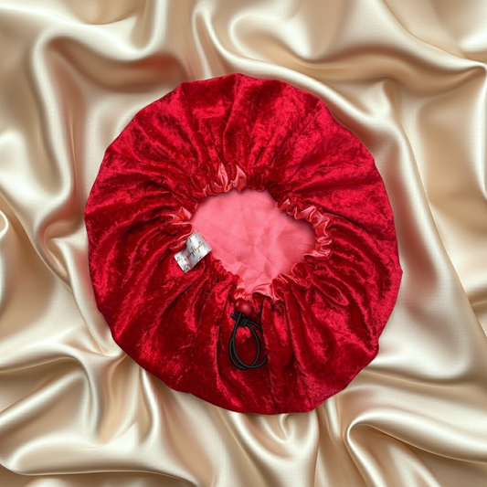 Red velvet drawstring bag with a pink interior on beige satin fabric