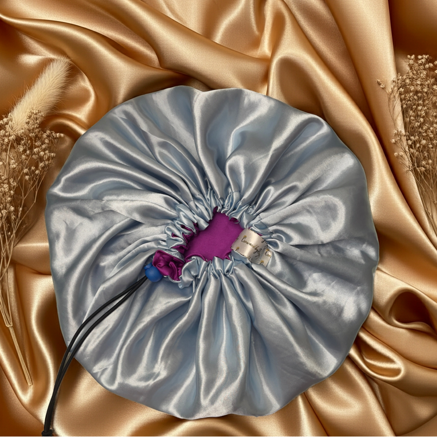 Silver drawstring bag with a purple tag on a gold satin background