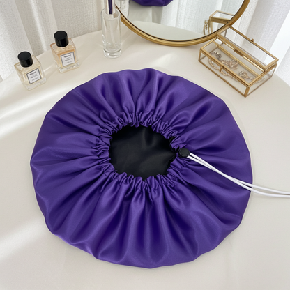 Purple drawstring bag on a white surface with a mirror and small items in the background