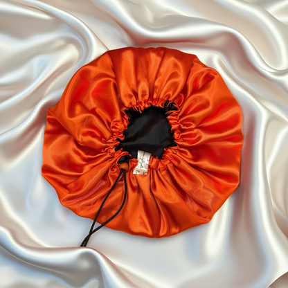 Orange drawstring bonnet on a white satin background