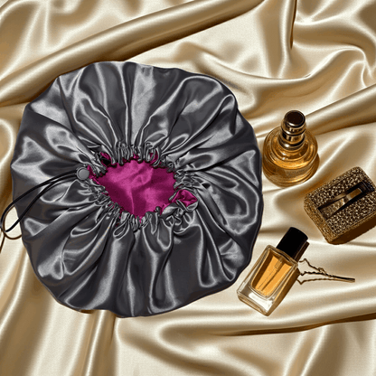 Silver drawstring bonnet with pink interior on a beige background