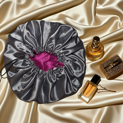 Silver drawstring bonnet with pink interior on a beige background