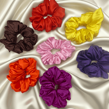 Set of colorful scrunchies on a satin surface